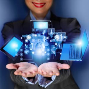 Picture of a lady holding out her hands with laptop, tablet and other technology icons hanging above them.